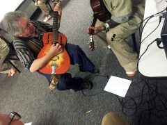 Blues musician Robin Henkel provides instruction (faces blocked to protect inmates' identity)